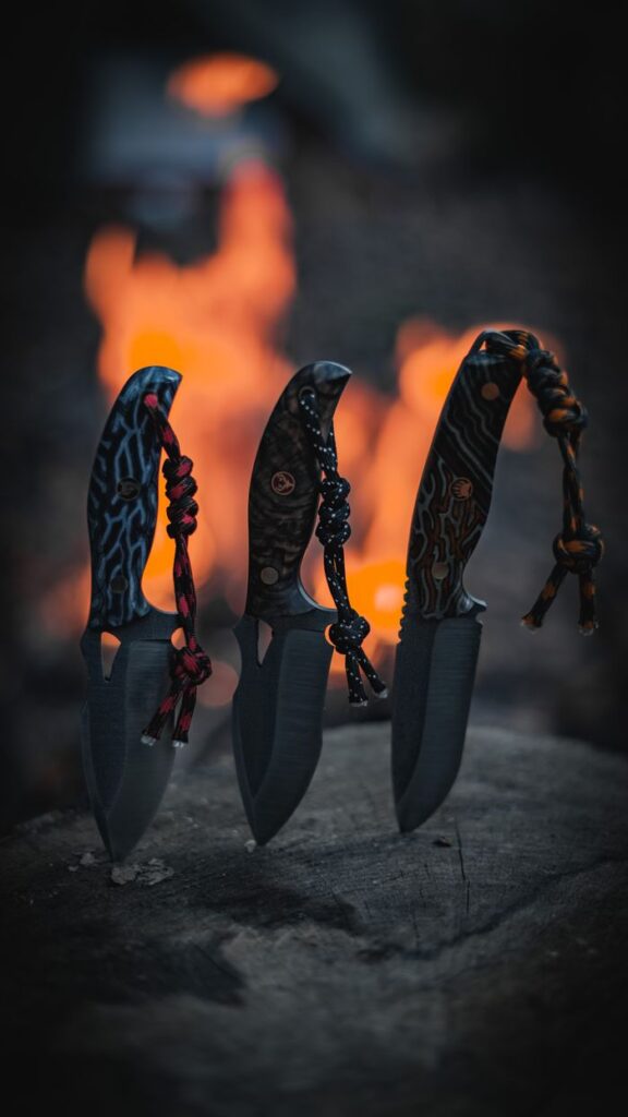 Hand-forged knives with intricate designs showcased against a fiery backdrop, highlighting craftsmanship.
